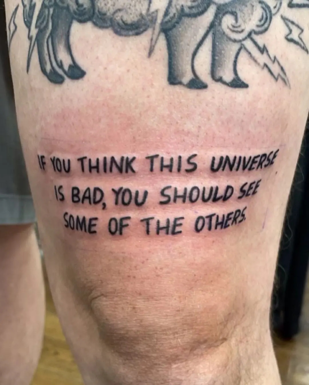 Quote on Above the Knee Tattoo